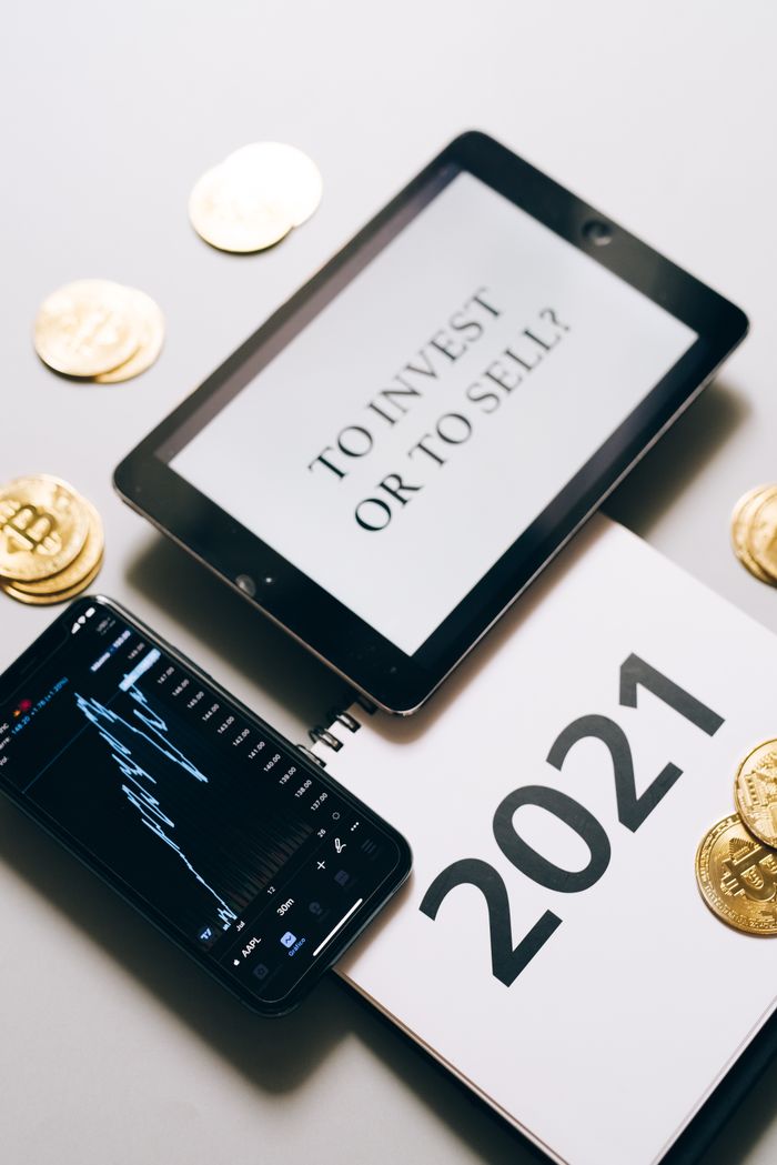 who-we-are Tablet with investment question amidst bitcoins and 2021 planner. Analyze crypto trends.